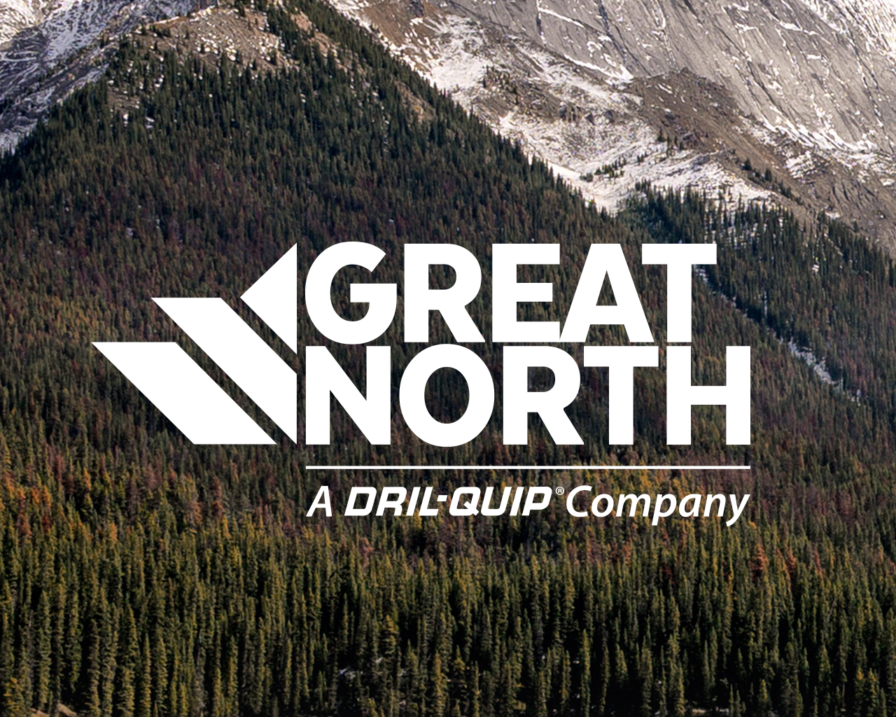 Great North, A Dril-Quip Company logo on top of the Canadian Rocky Mountains, snow covered mountains with a forest of evergreen trees.