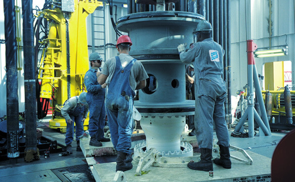 Several Dril-Quip employees at a drill site working on a diverter system.