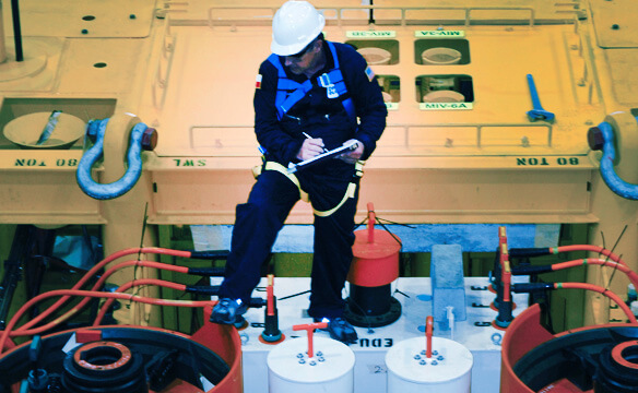 A Dril-Qup employee inspecting and taking notes on a subsea structure.